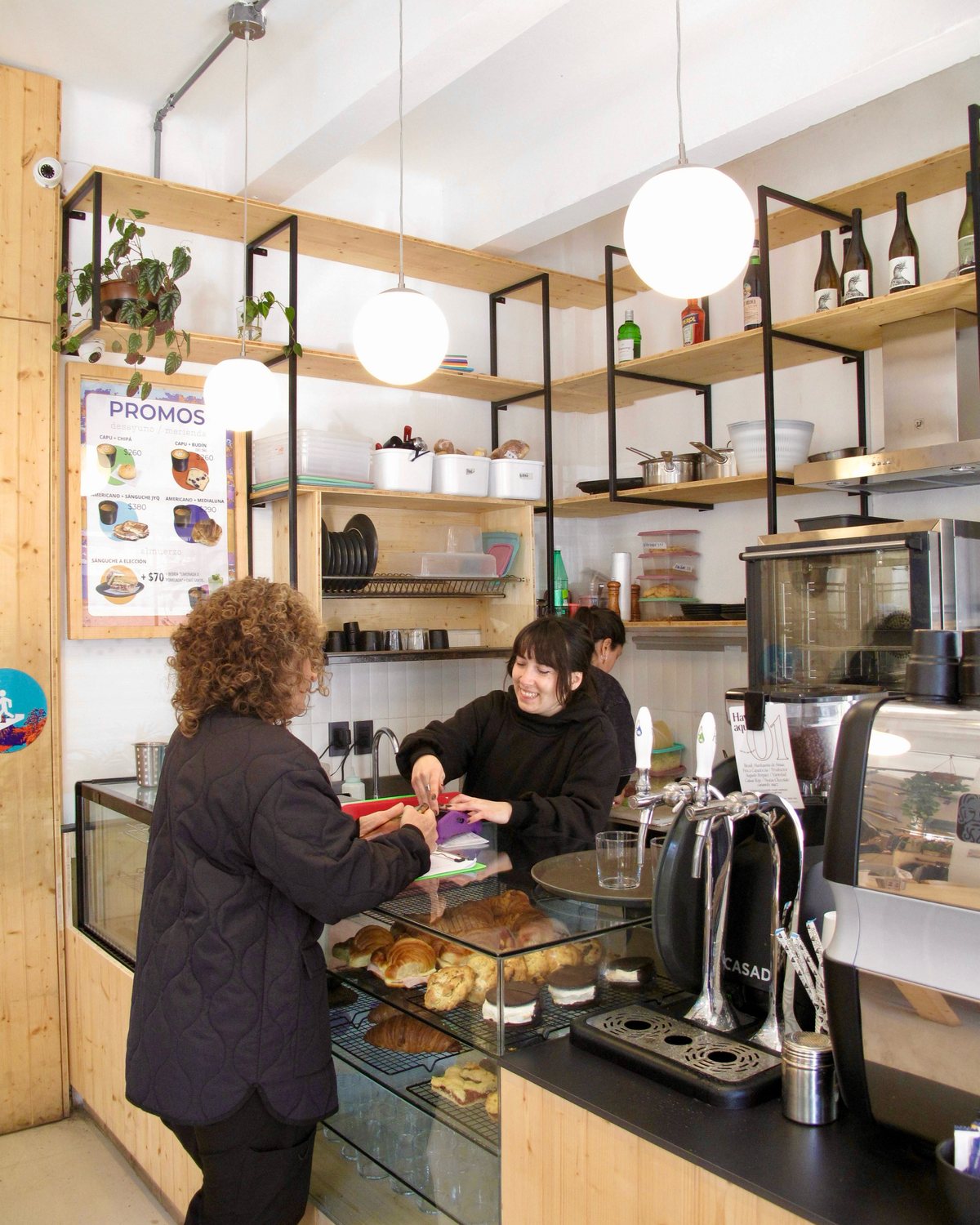 La barra de Mirador: la vitrina, la máquina de café y los estantes de madera