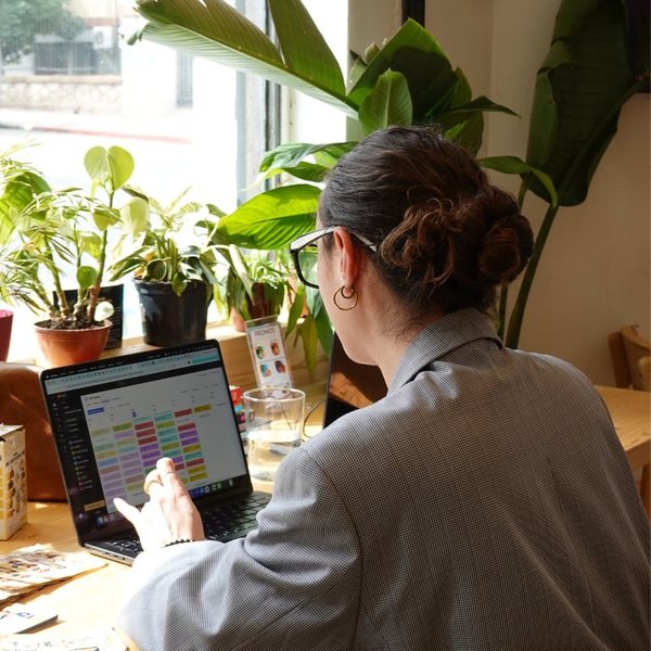Una clienta trabajando con su computadora en la barra de la ventana, entre plantas
